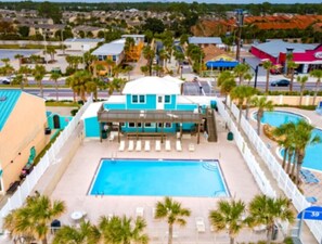 Ein Hotel mit Swimmingpool, Palmen und Blick auf die Umgebung.