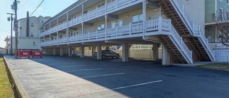 A multi-story motel with a central courtyard, outdoor parking, and a staircase leading to the upper floors.