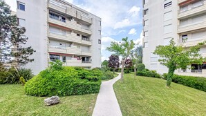 Ein Weg führt zu einem modernen Wohnhaus mit Balkonen und einem gepflegten Garten.