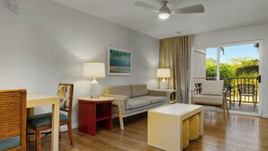 A modern living room with a sofa, chairs, a dining table, and a balcony with a view of greenery. - 2 Bedroom Twin at WorldMark Kihei (Kihei)