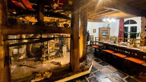 A dining area with a stone floor, wooden furniture, and a chandelier. - Beautiful home in Renty with WiFi (Renty)
