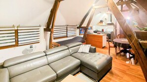 A cozy interior with a sectional sofa, a dining table, and a kitchen area. - 1 bedroom cozy home in RENTY (RENTY)