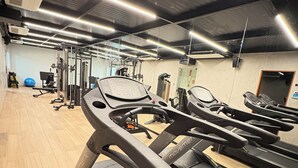 Ein Fitnessstudio mit Laufbändern, Trainingsgeräten und einem blauen Trainingsball.