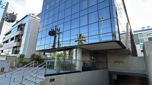 Ein modernes Gebäude mit Glasfassade, einer Treppe zum Eingang und einem Schild mit der Aufschrift "SETAI EDITION".