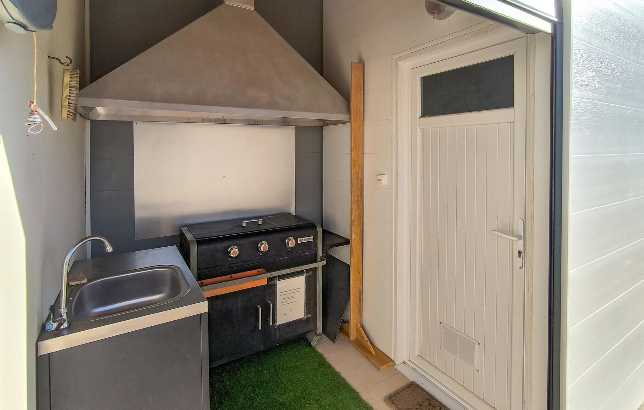 Een kleine keuken met een gasfornuis, een spoelbak en een klein aanrecht.