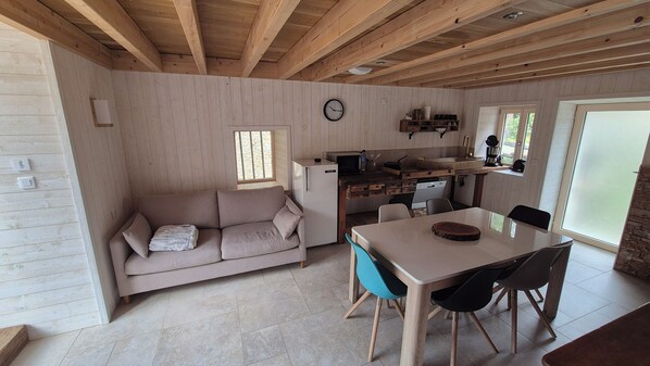Une pièce confortable avec un canapé, une table à manger et un coin cuisine.