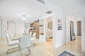 A modern interior with a dining area, kitchen, and bathroom.