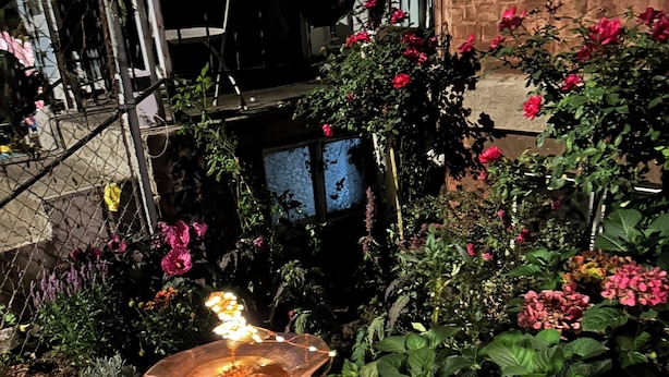 A garden with a variety of flowers and a decorative fountain.