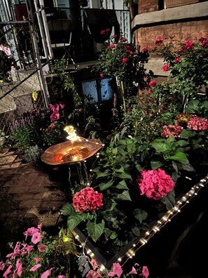 Ein Garten mit verschiedenen Blumen und einer Zierbrunnen.
