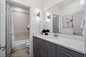 A modern bathroom with a bathtub, toilet, and a large mirror. - The Show House - Retreat for 10 (Washington)