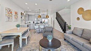 A modern kitchen with white cabinets, a central island, and pendant lighting. - The Show House - Retreat for 10 (Washington)