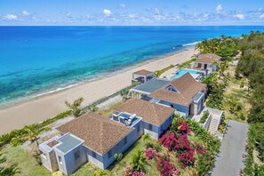 A beachfront property with multiple villas, a swimming pool, and a beach view. - Turtle Nest vibrant tropical garden (Les Terres Basses)