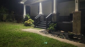 A house with a covered porch, a visible number '5116' on a pillar, and a well-maintained lawn.