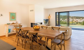 A dining area with a wooden table and chairs, a bowl of fruit, and a television. - Villa Pietra Mare, piscine vue mer, à l'Ile-Rousse (L'Ile-Rousse)