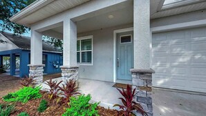 A modern two-story house with a covered porch, stone pillars, and a garage. - Cozy Downtown Tampa Retreat (Tampa)