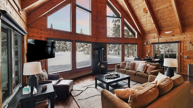 A spacious living room with a large TV, comfortable seating, and a fireplace. - McCall A-Frame on Golf Course, 5 Minutes from Town + Huge Yard, Hot Tub & 7 Beds (McCall)