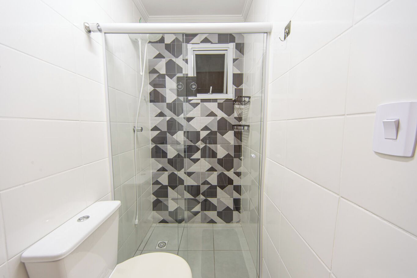 Une petite salle de bain avec une douche à parois de verre, des toilettes et un lavabo avec un miroir.