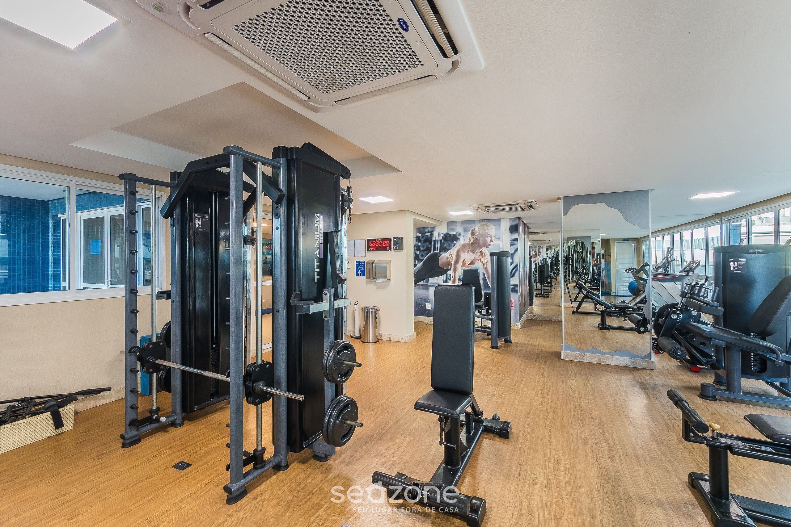 Un gimnasio con diverso equipo de ejercicio, que incluye una estructura para sentadillas y bancos de pesas.