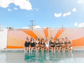 A group of people sitting by a pool with a colorful wall in the background. - The Pine Desert Retreat - Scottsdale's Ultimate Getaway (Scottsdale)