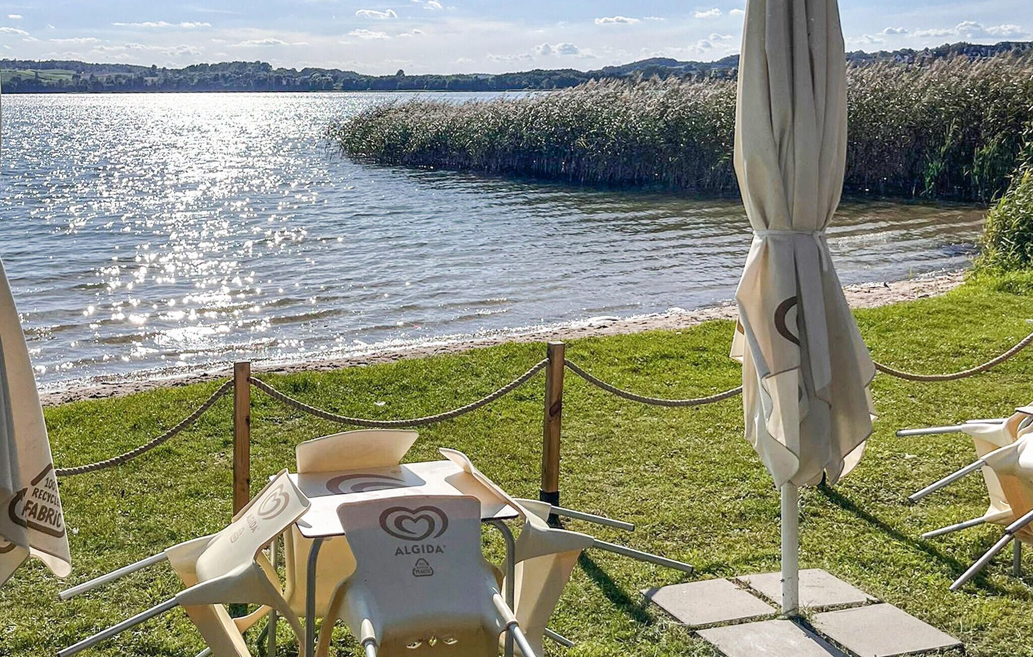 Uteservering med utsikt över en sjö och avlägsna kullar.