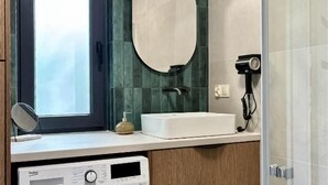 A bathroom with a white sink, a round mirror, a handheld hair dryer, and a window with a view. - Awesome home in Sianowo with WiFi (Sianowo)