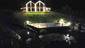 A house with a symmetrical roof and a well-lit front porch. - Awesome home in Sianowo with WiFi (Sianowo)