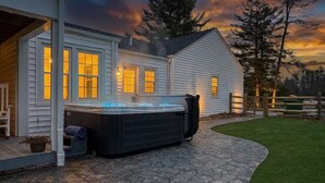 A house with a hot tub, stone patio, and a wooden fence. - Hot Tub • Fenced Yard • Perfect Family Retreat Near Chagrin Falls (Geauga County)