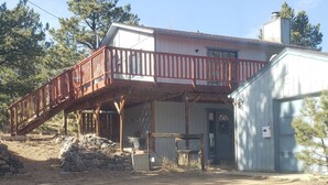 A building with a wooden deck and a garage. - Welcoming 2-bedroom house in Bailey perfect for your getaway. (Bailey)