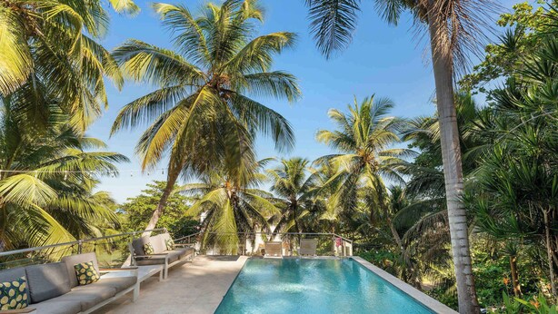 Un espace aménagé au bord de la piscine, avec un long banc et une petite piscine.