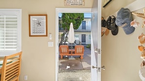 En døråbning, der fører ud til en balkon med et skilt, der siger 'BEACH', et billede af en rammet søstjerne og et skilt over døren, der siger 'PARADISE FOR'.