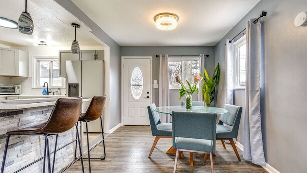 A modern kitchen with a central island, bar stools, and pendant lighting.