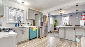 A modern kitchen with a dishwasher, refrigerator, and a stove.
