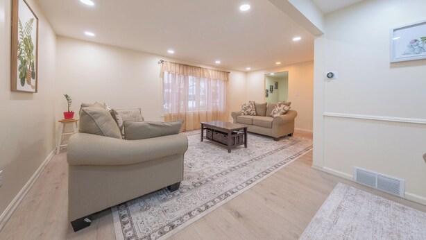 A living room with a sofa, a coffee table, and a second seating area with a couch.