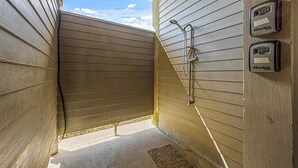 A small, enclosed shower area with wooden walls and a sloped ceiling. - Blissful Waves - Pet Friendly, Walk to the Beach! (Bolivar Peninsula)