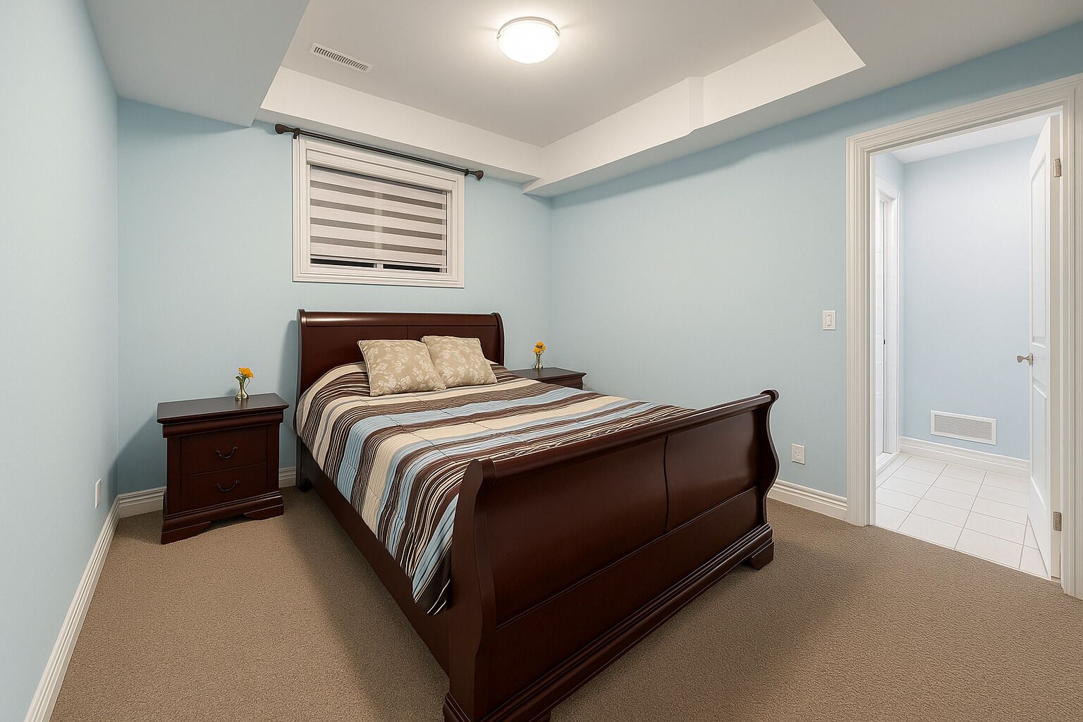 A bedroom with a dark wooden bed, a nightstand with a vase, a window with blinds, and a door.