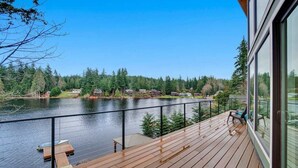 Eine Holzterrasse mit Blick auf einen See und einen Wald.