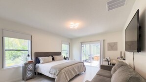 Een moderne slaapkamer met een groot bed, een bank en een televisie.