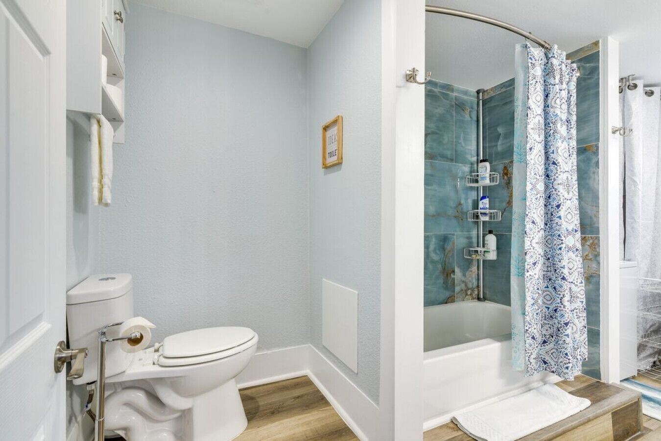 Une salle de bain équipée de toilettes, d’une douche et d’un porte-serviettes.