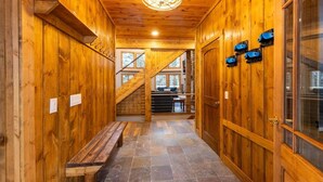 A wooden hallway with a bench, stone flooring, and a staircase leading to a seating area. - PoStickNo Lodge: 6BR/6.5BA Ski-In/Out Pet-Friendly (Snowshoe)