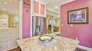 Una cocina con encimera de mármol, electrodomésticos de acero inoxidable y un cuenco decorativo.