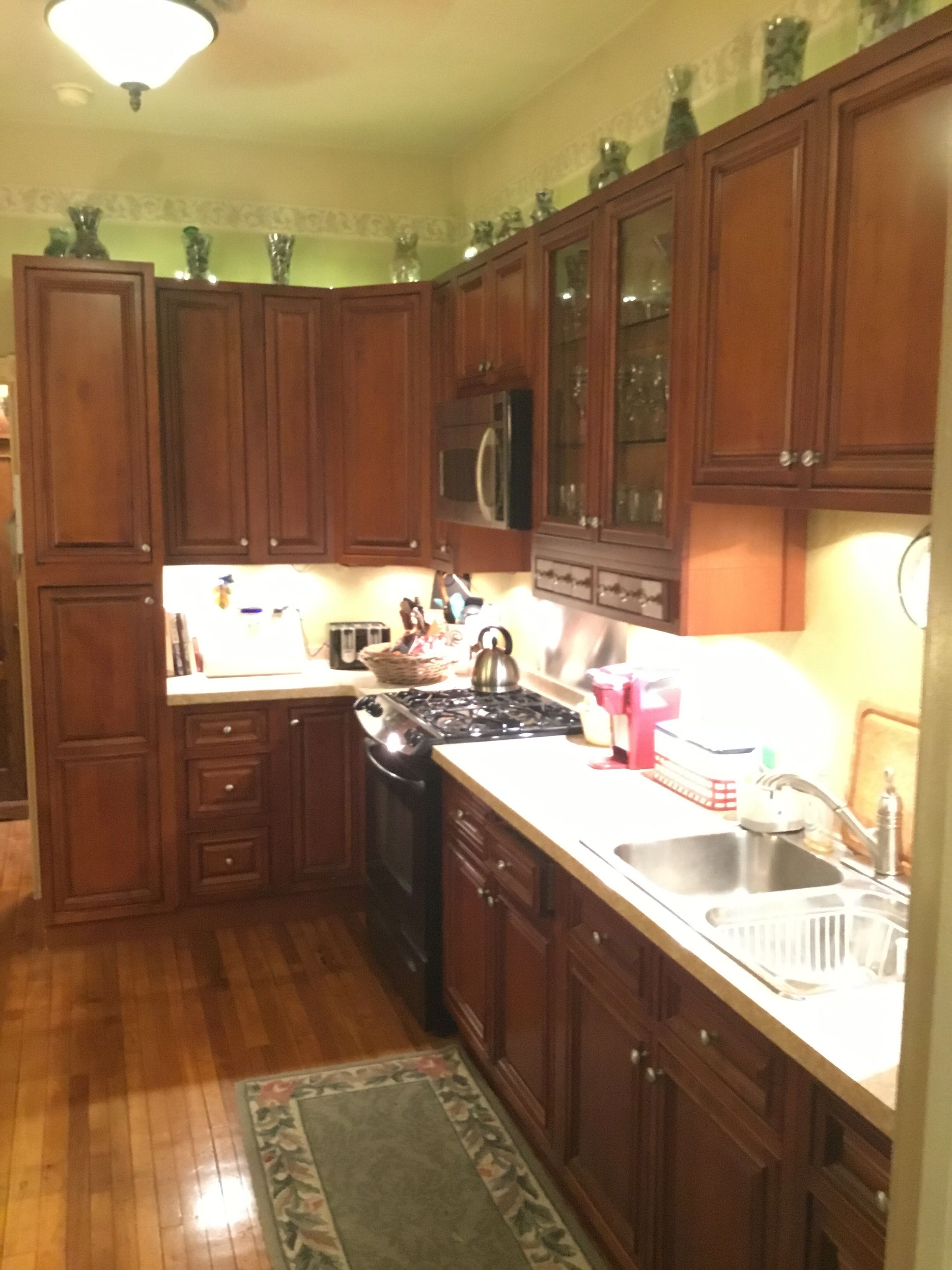 A kitchen with wooden cabinets, a stove, a microwave, and a sink.