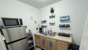 A compact kitchen with a microwave, toaster, sink, and a small trash bin. - Private, Cozy, Clean apartment in lovely Hyde Park (Hyde Park)