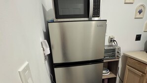 A compact kitchen with a stainless steel refrigerator, a microwave, and a toaster. - Private, Cozy, Clean apartment in lovely Hyde Park (Hyde Park)