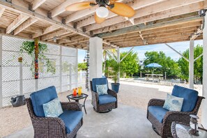 A covered outdoor seating area with wicker furniture and a concrete floor. - Updated Canal Home with Dock for 25' Boat, Sandbar Access & Backcountry Fishing (Big Pine Key)