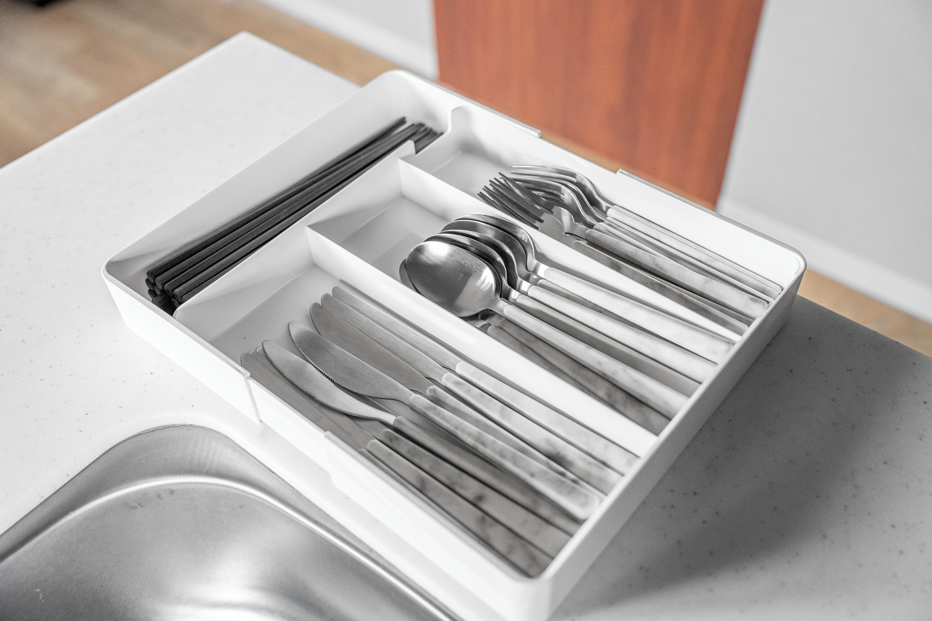 A drawer with utensils including forks, knives, and spoons.