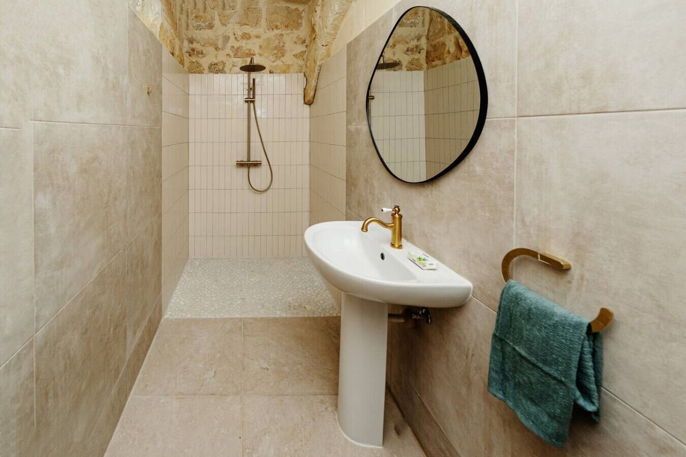 Baño con ducha, lavamanos y espejo.