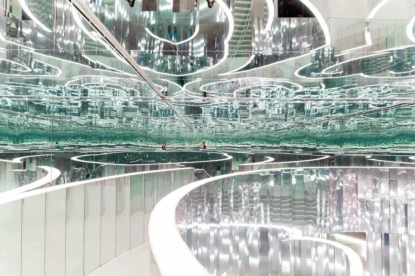 A modern interior with reflective surfaces and circular patterns on the walls and floor.