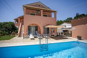 A two-story building with a swimming pool, outdoor seating, and a staircase leading to the entrance. - Stay close to beaches and tavernas while enjoying your own private pool (Gazatika)