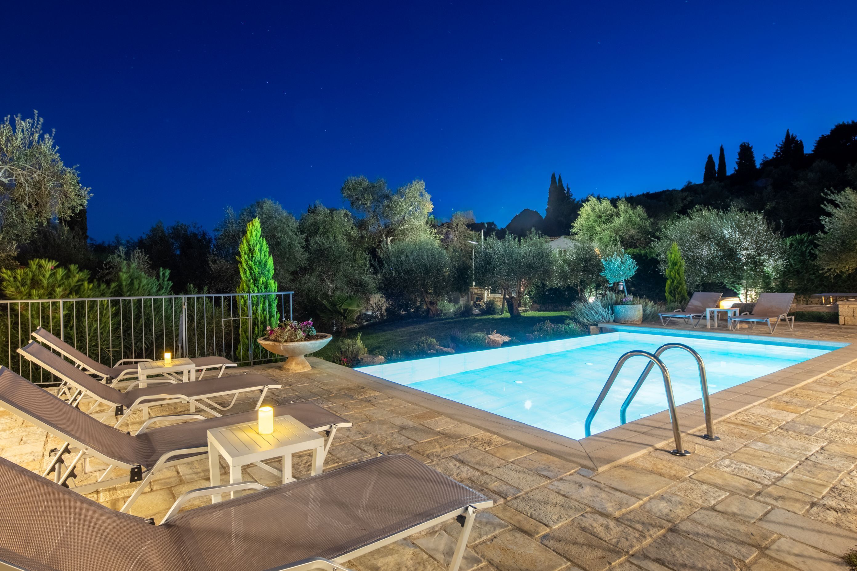 Ein Swimmingpool mit Liegestühlen und einer Steindeck.