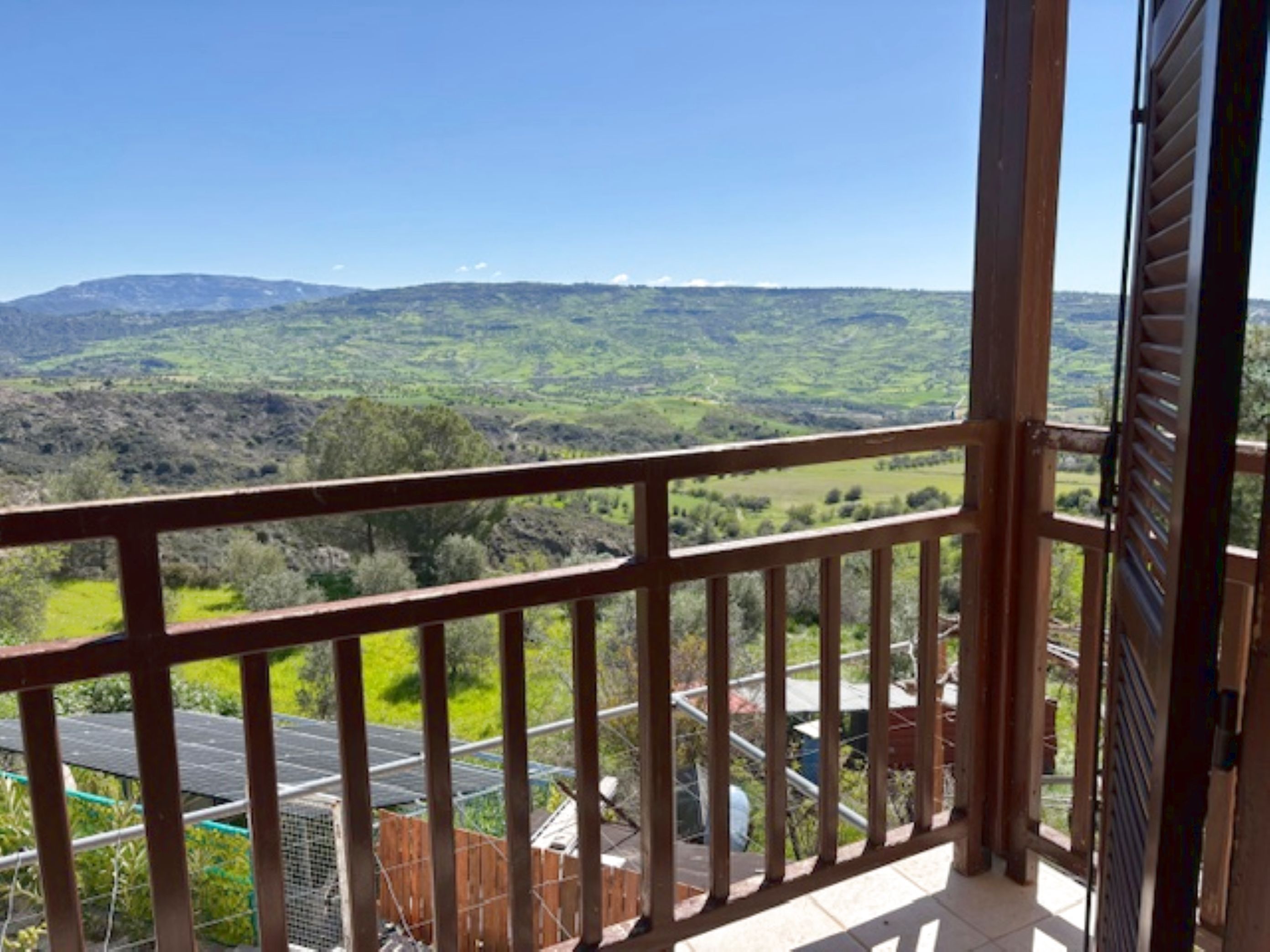 Un balcon donnant sur un paysage vallonné.